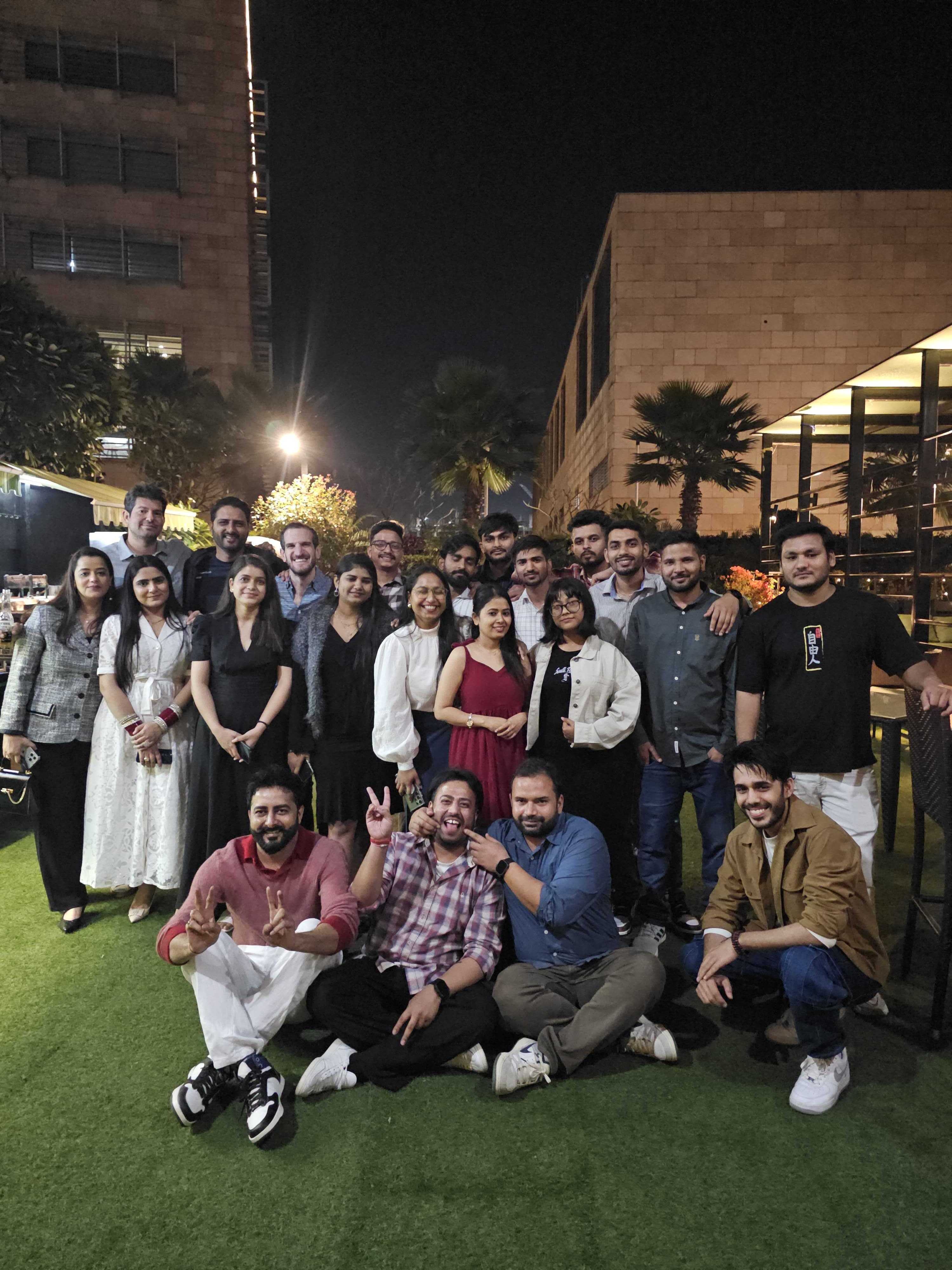 Manu with friends and colleagues outdoors at night